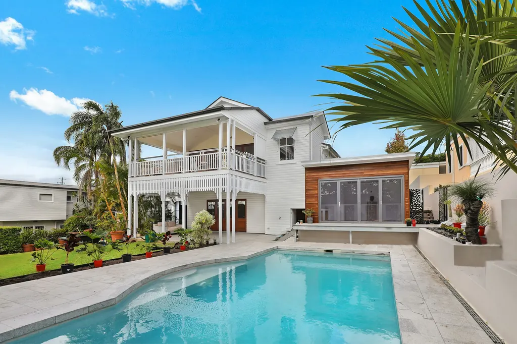 Family home with a backyard pool and palm trees